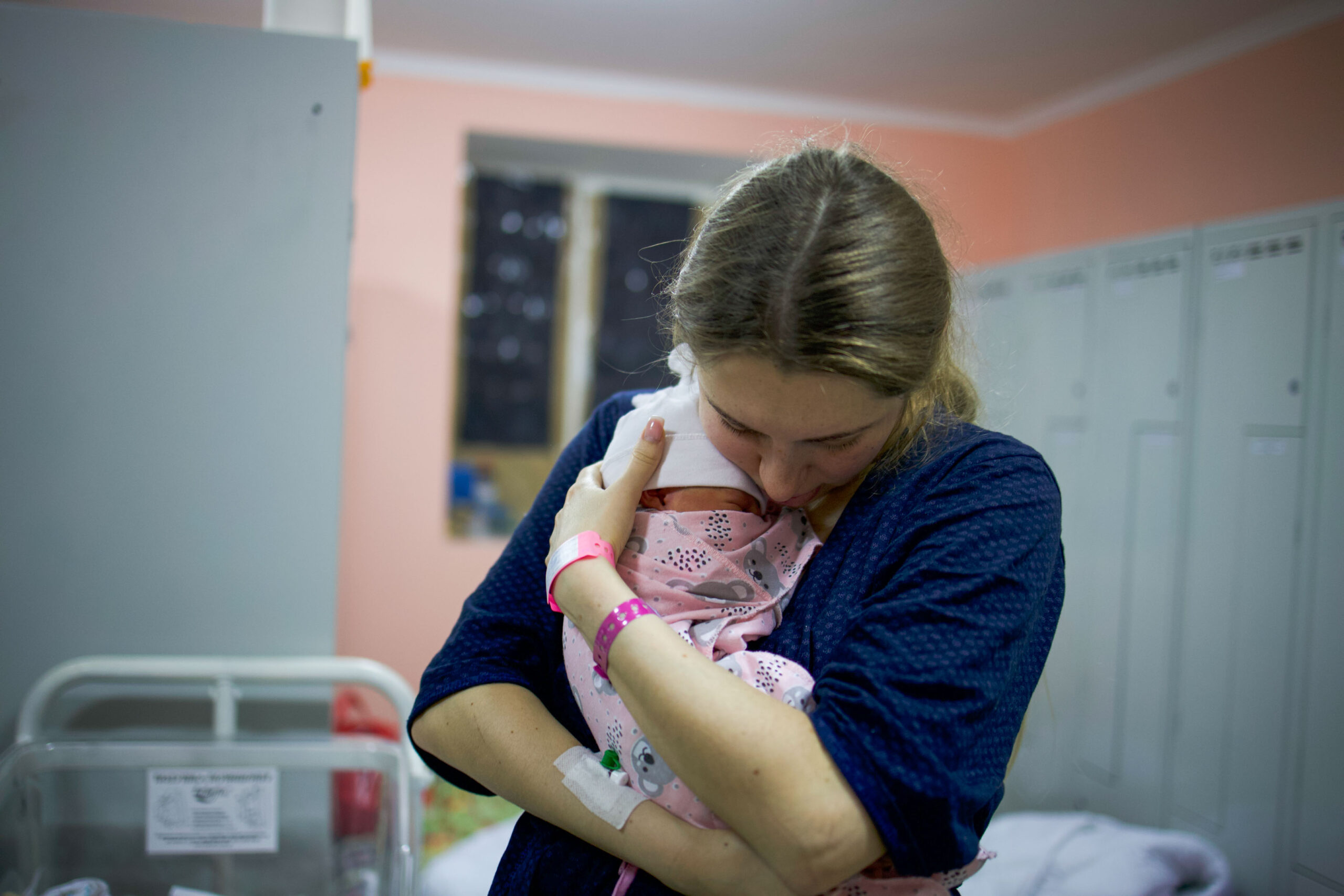 En kvinna håller sitt nyfödda barn i ett skyddsrum