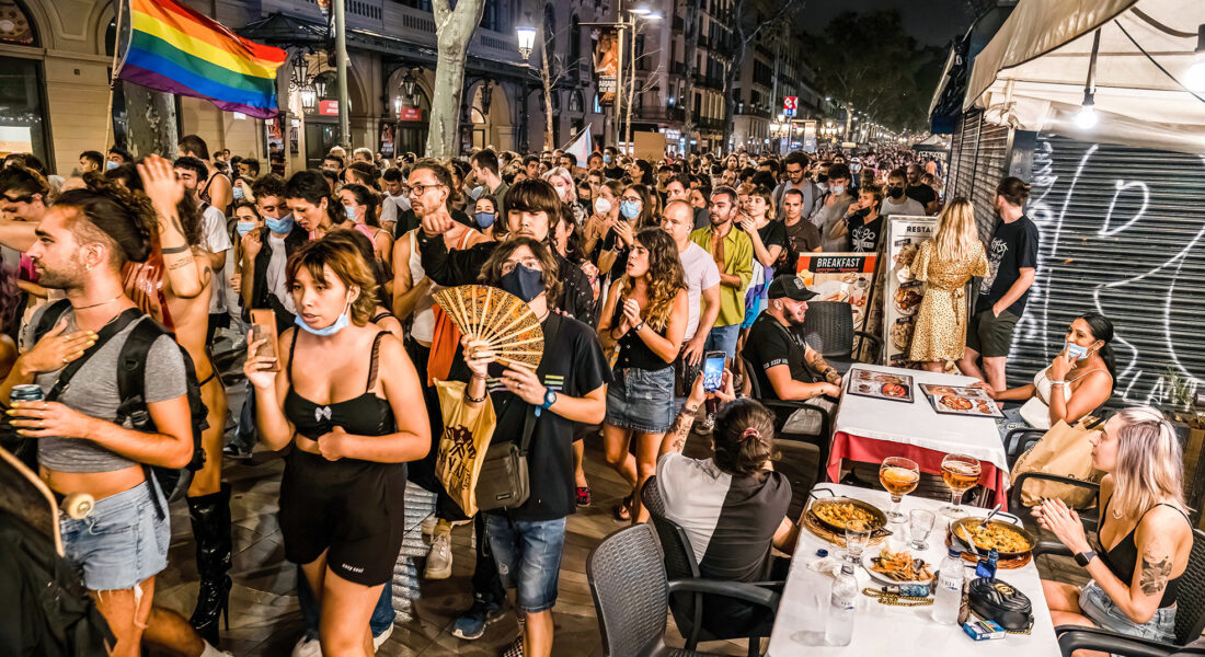 Människor som demonstrerar med regnbågsflagga i Barcelona.